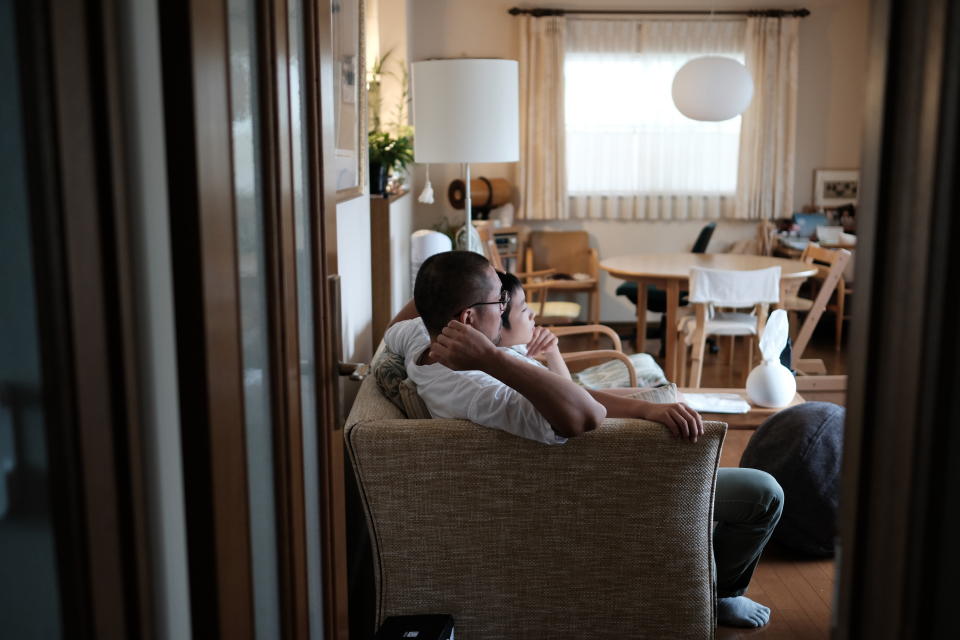 Boy and father watching television sitting on the sofa together