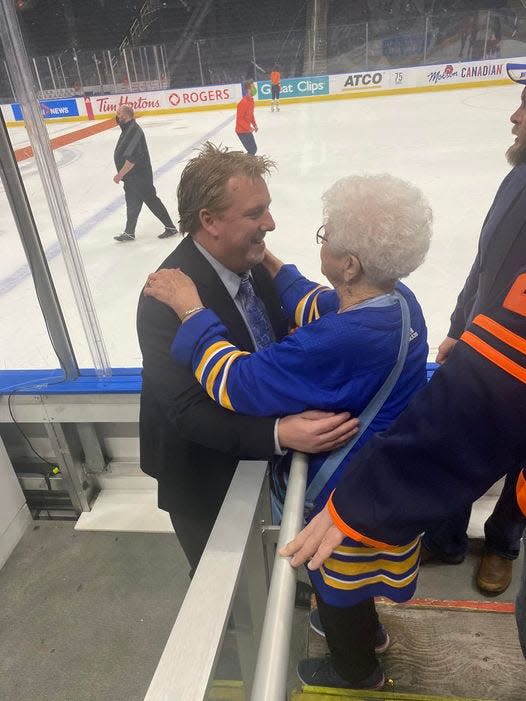 Former Peoria Rivermen player and head coach Jason Christie, now an assistant coach in the NHL with Buffalo, hugs his grandmother, who was part of a large family contingent that traveled to Edmonton to see Christie and the Sabres on March 17, 2022.