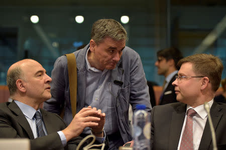 European Economic and Financial Affairs Commissioner Pierre Moscovici (L) chats with Greece's Finance Minister Euclid Tsakalotos (C) and European Commission Vice-President Valdis Dombrovskis during a Euro zone finance ministers meeting, to discuss whether Greece has passed sufficient reforms to unblock new loans and how international lenders might grant Athens debt relief, in Brussels, Belgium May 24, 2016. REUTERS/Eric Vidal