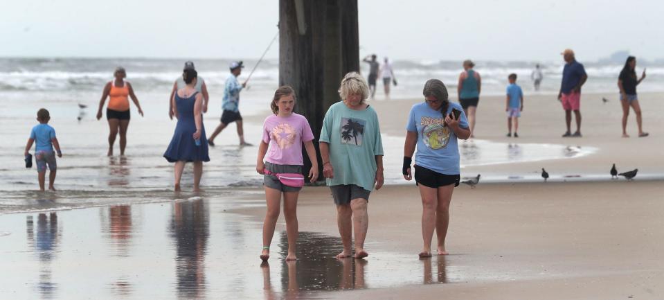 Beachgoers stroll near the Daytona Beach Pier on Wednesday. Things were not so quiet over Memorial Day weekend, as Beach Safety plucked more than 300 people from dangerous surf conditions.