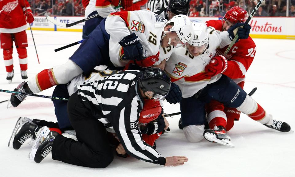 Linesman Ryan Galloway tries to break up a fight between Panthers left wing Matthew Tkachuk (19) and Red Wings defenseman Ben Chiarot, bottom, with Dylan Larkin (71) trying to pull Sam Reinhart (13) off the pile, during the second period on March 2, 2024, at LCA.