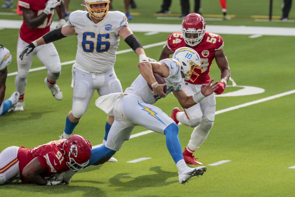 Chargers quarterback Justin Herbert slips away from Chiefs defensive tackle Derrick Nnadi.