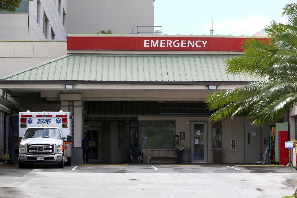 An ambulance is parked outside the emergency room at The Queen's Medical Center in Honolulu, Tuesday, Aug. 24, 2021. (AP Photo/Caleb Jones)