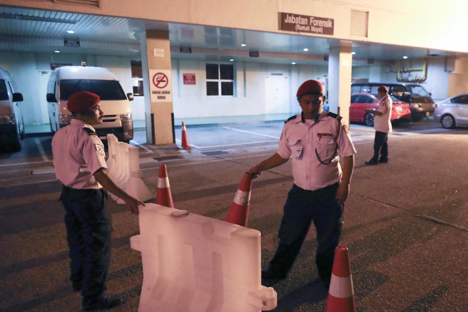 Personal de seguridad vigila la entrada al departamento forense del hospital en Putrajaya, Malasia, martes 14 de febrero de 2017. La policía dice que un norcoreano murió camino del hospital desde el aeropuerto de Kuala Lumpur. (AP Foto/Vincent Thian)