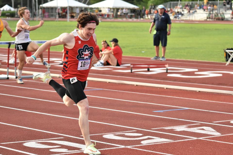 Zane Thompson dips across the finish line to win his heat of the 300-meter hurdles at the 2022 IHSAA Boys' Track and Field State Finals.