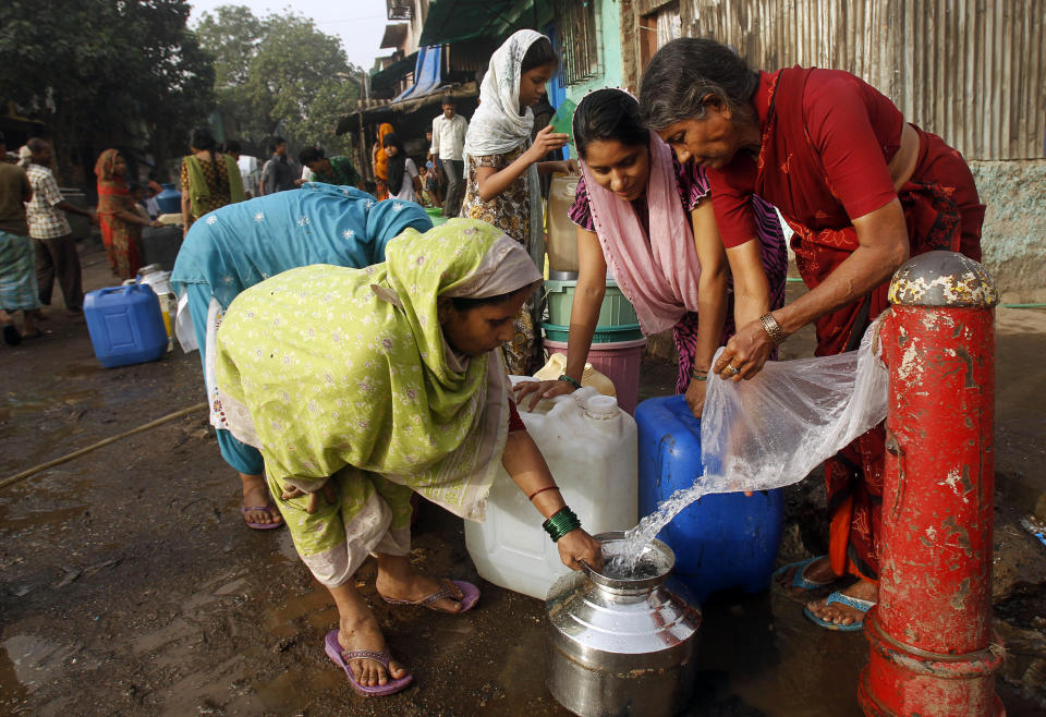 Indian women collect water from a broken pipe in a slum on the outskirts of Mumbai, India, Thursday, March 22, 2012. The U.N. estimates that more than one in six people worldwide do not have access to 20-50 liters (5-13 gallons) of safe freshwater a day to ensure their basic needs for drinking, cooking and cleaning. (AP Photo/Rafiq Maqbool)