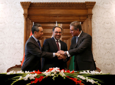 Afghanistan's Foreign Minister Salahuddin Rabbani (C), Pakistan's Foreign Minister Shah Mehmood Qureshi and Chinese Foreign Minister Wang Yi shake hands after a memorandum of understanding on cooperation in fighting terrorism, signed in Kabul, Afghanistan December 15, 2018. REUTERS/Mohammad Ismail