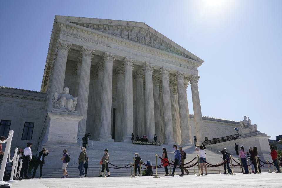 People pay respects as Justice Ruth Bader Ginsburg lies in repose under the Portico at the top of the front steps of the U.S. Supreme Court building on Wednesday, Sept. 23, 2020, in Washington. Ginsburg, 87, died of cancer on Sept. 18. (AP Photo/Patrick Semansky)