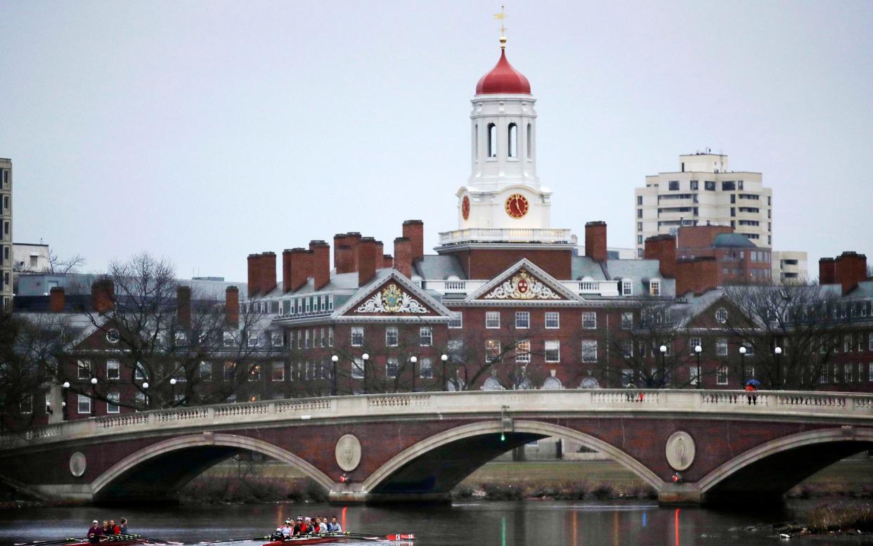 Rowers paddle along the Charles River past the Harvard College campus in Cambridge, Massachusetts - AP