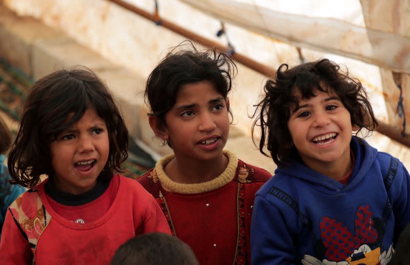 Students sit together at a makeshift school in a tent in Azaz