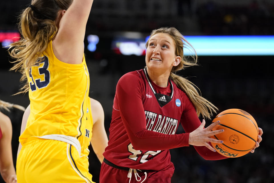 South Dakota's Maddie Krull (42) heads to the basket as Michigan's Emily Kiser (33) defends during the first half of a college basketball game in the Sweet 16 round of the NCAA women's tournament Saturday, March 26, 2022, in Wichita, Kan. (AP Photo/Jeff Roberson)