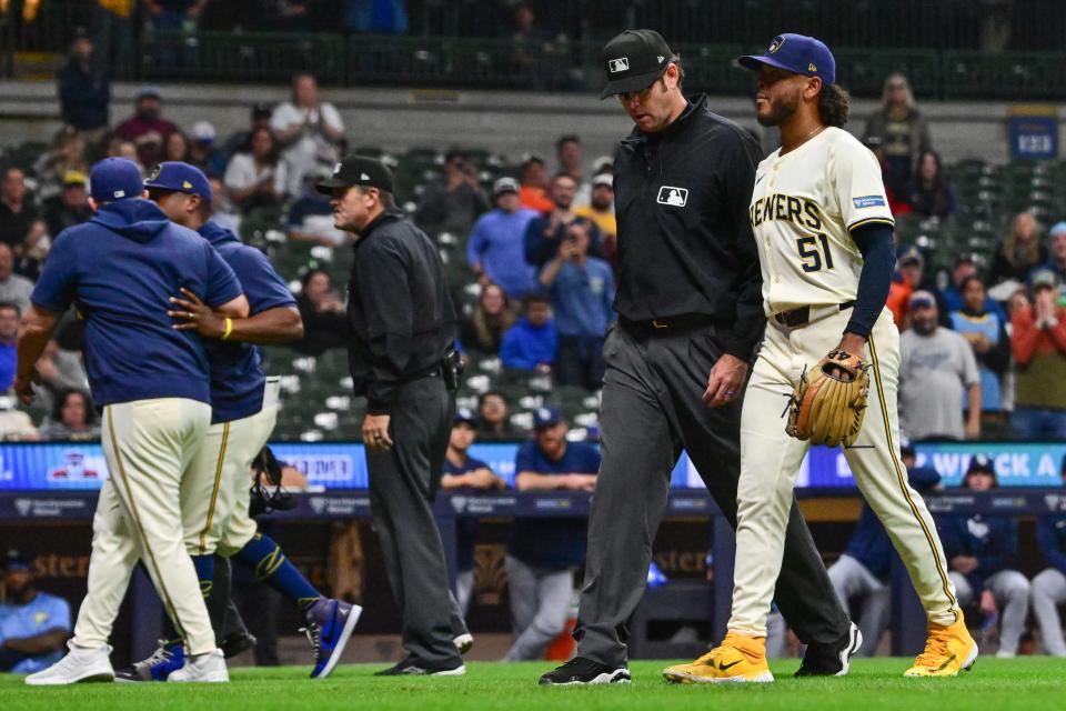 Brewers pitcher Freddy Peralta is escorted off the field by third base umpire Ryan Additon after he was ejected for hitting the Rays' Jose Siri with a pitch in the sixth inning Tuesday night. Brewers manager Pat Murphy (upper left) was also ejected after arguing the decision.