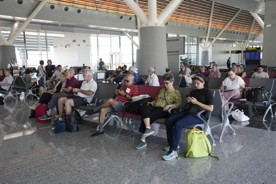 Tourists wait before departure at the Siem Reap-Angkor International Airport in Cambodia, as it opens Thursday, Nov. 16, 2023. Cambodia on Thursday officially inaugurated the country's newest and biggest airport, a Chinese-financed project meant to serve as an upgraded gateway to the country’s major tourist attraction, the centuries-old Angkor Wat temple complex in the northwestern province of Siem Reap. (AP Photo/Heng Sinith)