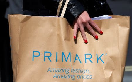 FILE PHOTO: A shopper walks past a branch of clothing retailer Primark in London, Britain April 27, 2013. REUTERS/Suzanne Plunkett/File Photo