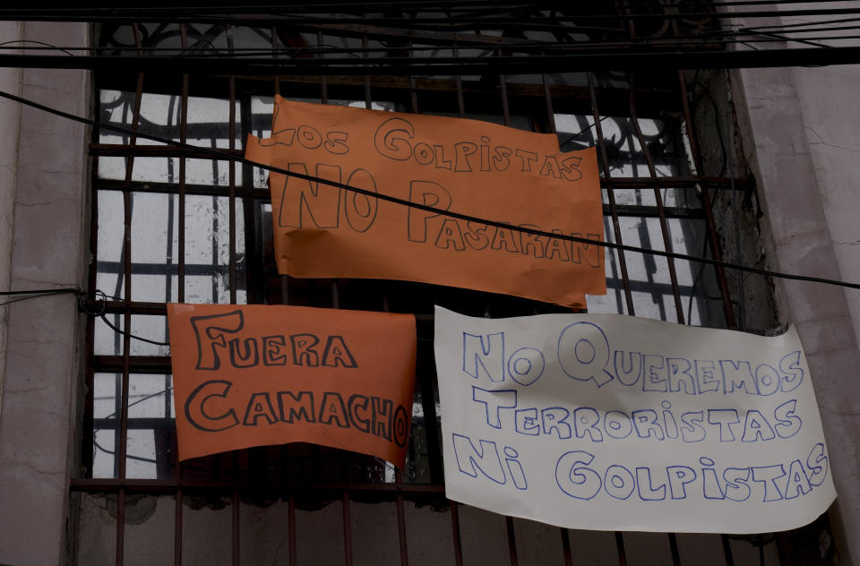 Signs hang from a window of the San Pedro jail with messages that read in Spanish: "Coup leaders will not pass", "Camacho Out" and "We do not want terrorists nor coup leaders", against the possible transfer of Santa Cruz Gov. Luis Fernando Camacho to the detention facility in La Paz, Bolivia, Thursday, Dec. 29, 2022. Police on Wednesday detained Camacho, the main opposition leader in Bolivia, near his Santa Cruz home. The Chief Prosecutor’s Office said Camacho was detained as part of a case in which he is accused of leading what the government characterizes as a coup in 2019. (AP Photo/Juan Karita)