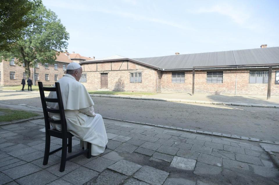 Pope Francis during a moment of reflection as he sits in front of camp buildings in Auschwitz. <span class="inline-image-credit">(EPA/Osservatore Romano)</span>