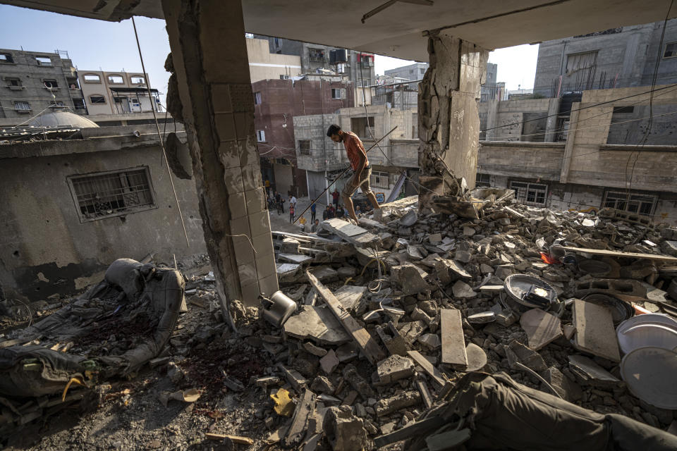 FILE - Palestinians look at the destruction after Israeli strikes on the Gaza Strip in Khan Younis on Now. 3, 2023. Entire generations of Palestinian families in the besieged Gaza Strip have been killed in airstrikes in the ongoing Hamas-Israel war. They include infants to elderly grandparents, killed in attacks the Israeli army says aim to root out the militant group from the densely populated coastal territory. (AP Photo/Fatima Shbair, File)