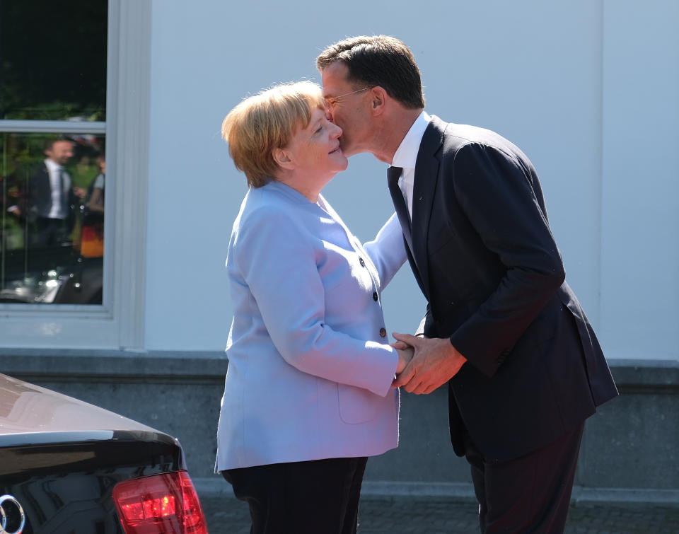 Dutch Prime Minister Mark Rutte, right, greets German Chancellor Angela Merkel in The Hague, Netherlands, Thursday Aug. 22, 2019. Merkel and key Cabinet ministers are meeting their Dutch counterparts Thursday to discuss ways of tackling climate change together, as Germany is set to miss its emissions goals for 2020 by a wide margin.(AP Photo/Mike Corder)
