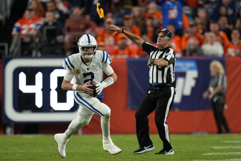 The referee throws a flag as Indianapolis Colts quarterback Matt Ryan (2) runs during the first half of an NFL football game against the Denver Broncos, Thursday, Oct. 6, 2022, in Denver. (AP Photo/Jack Dempsey)