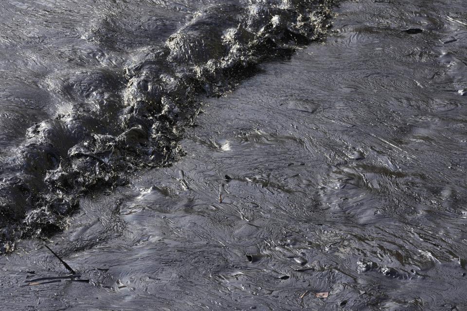 Oil from a spill covers the shore at Cavero beach in Ventanilla, Callao, Peru, Monday, Jan. 17, 2022. Unusually high waves that authorities attribute to the eruption of the undersea volcano in Tonga caused the spill on the Peruvian Pacific coast as a ship was loading oil into La Pampilla refinery on Sunday. (AP Photo/Martin Mejia)