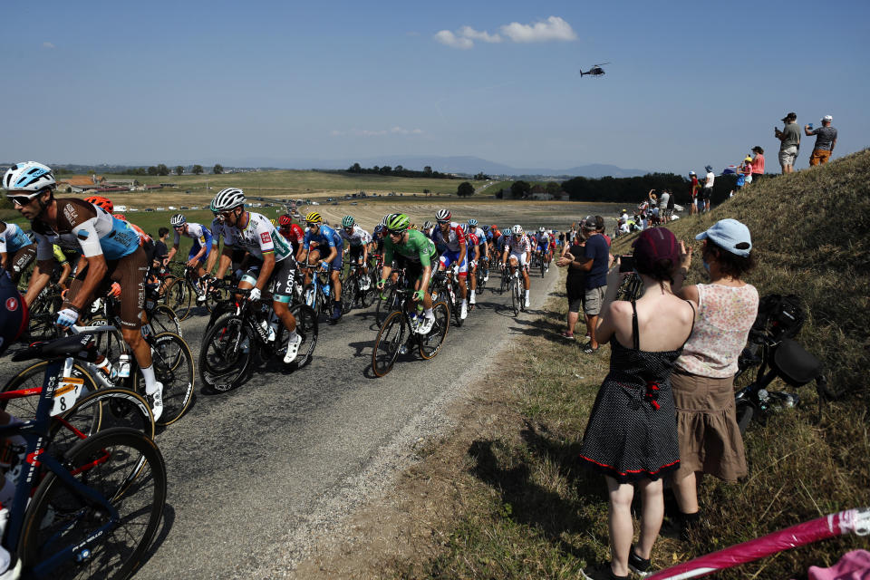 Unas personas toman fotografías de los ciclistas durante la 16ta etapa del Tour de Francia en La Tour-du Pin, Francia, el martes 15 de septiembre de 2020. (AP Foto/Thibault Camus)