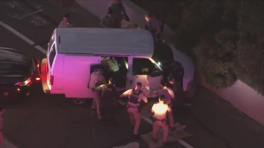 Officers swarmed the van, opening the back sliding door and dragging the man outside. (KTLA)