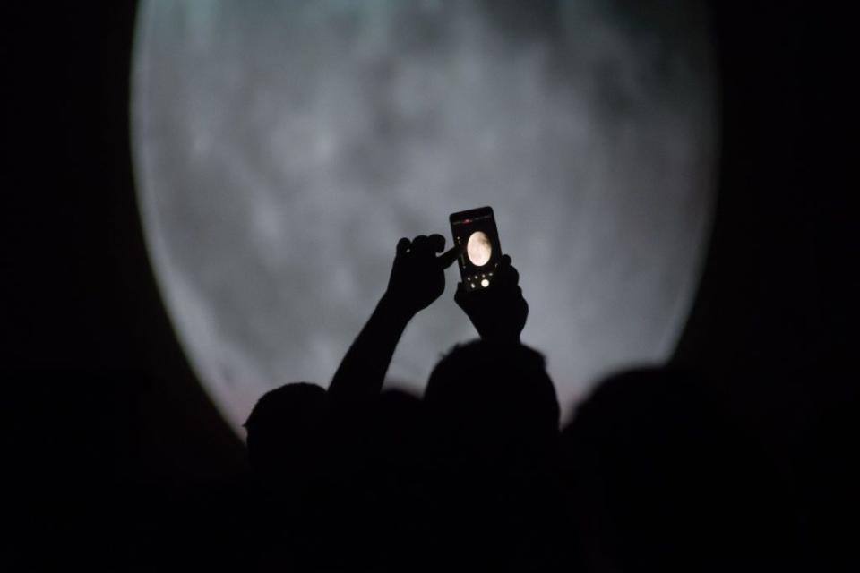 A man pictures a projection of a blood moon over Madrid...