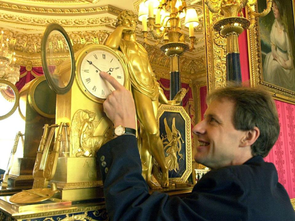 Clock maker at Windsor Castle, Steven Davidson puts a clock back by one hour in the Crimson Room to mark the end of British Summer Time.