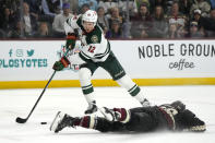 Minnesota Wild left wing Matt Boldy (12) avoids Arizona Coyotes center Travis Boyd in the second period during an NHL hockey game, Monday, Feb. 6, 2023, in Tempe, Ariz. (AP Photo/Rick Scuteri)