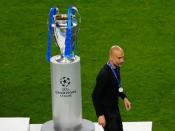 El entrenador del Manchester City, Pep Guardiola, camina por delante del trofeo de la Champions League
