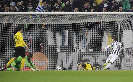 Juventus' Carlos Tevez (R) shoots to score against Borussia Dortmund during their Champions League round of 16 first leg soccer match at the Juventus stadium in Turin February 24, 2015. REUTERS/Giorgio Perottino