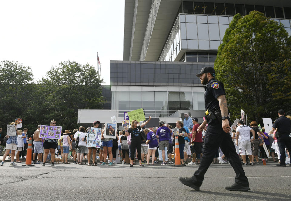 FILE - In this Aug. 17, 2018 file photo, family and friends who have lost loved ones to OxyContin and opioid overdoses protest outside Purdue Pharma headquarters in Stamford, Conn. The Sackler family’s ties to OxyContin and the painkiller’s role in the deadly opioid crisis are bringing the Sacklers a new kind of attention and complicating their philanthropic legacy. (AP Photo/Jessica Hill, File)