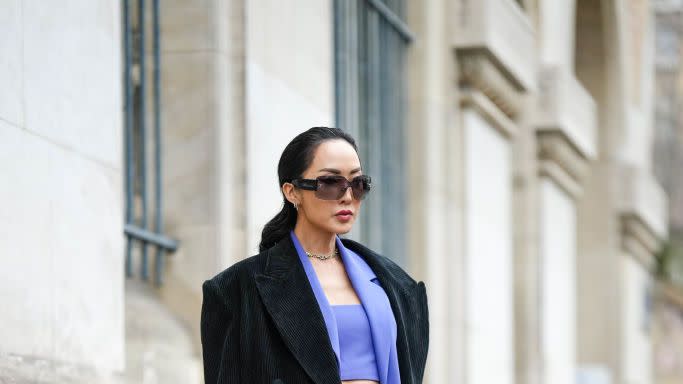 chriselle lim wears a crop top suit blazer and trousers with a large black coat in a guide to the best bras for small busts 2023