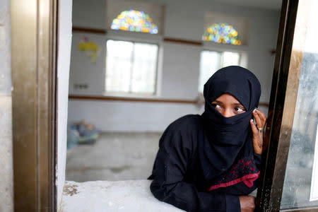 FILE PHOTO: A girl displaced from the Red Sea port city of Hodeidah looks from the window of a class room at a school where IDPs temporarily live in Sanaa, Yemen July 1, 2018. REUTERS/Khaled Abdullah/File Photo