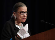 FILE - This Sept. 20, 2017, file photo shows Supreme Court Justice Ruth Bader Ginsburg speaking at the Georgetown University Law Center campus in Washington. Ginsburg didn’t put on her judge’s robe without also fastening something around her neck. Ginsburg called her neckwear collars, or jabots, and they became part of her signature style, along with her glasses, lace gloves and fabric hair ties known as scrunchies. (AP Photo/Carolyn Kaster, file)