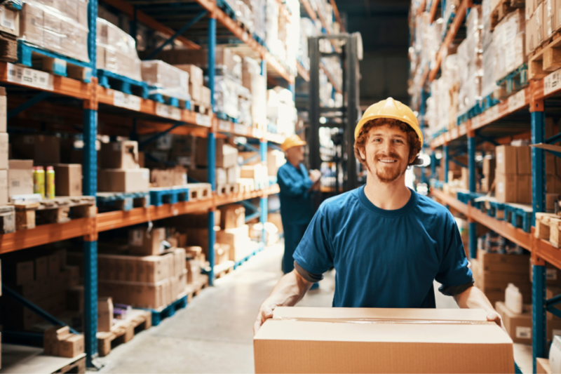 Man Carrying Box in Warehouse