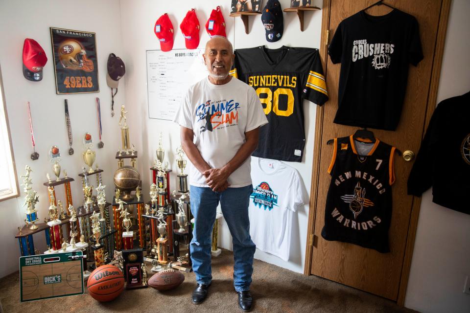 Manuel Pacheco, also known as Coach Manny, poses for a portrait in front of the trophies his players have earned over his coaching career on Tuesday, Aug. 30, 2022, at his home. Pacheco announced he is retiring as a football and basketball coach after more than 30 years of serving the Las Cruces community.