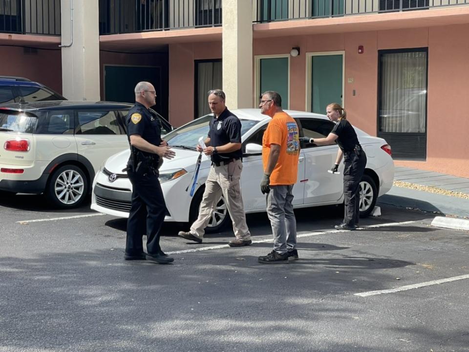 TPD officers, pictured with a tow truck driver, respond Monday to the Baymont Inn & Suites on North Monroe Street, where two men were taken in for questioning. TPD said investigators were trying to determine whether the men were involved in the shooting that injured an officer earlier in the day.