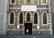 A woman walks past signs announcing the permanent closure of the Fugard Theatre in Cape Town