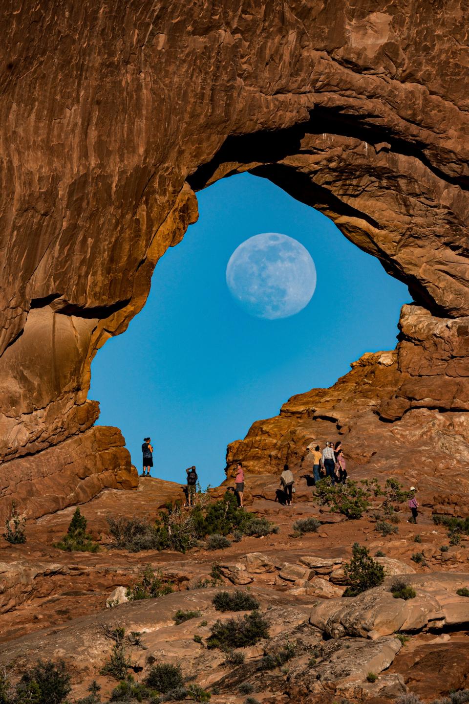 The nearly full Flower Moon rises in the middle of the North Window Arch in Arches National Park in Utah on May 24, 2021.