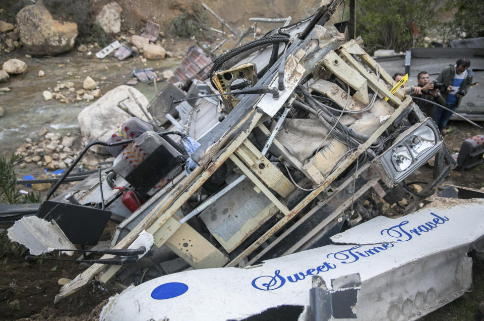 The debris of a regional bus that crashed off a hill are pictured Sunday Dec.1, 2019, causing the death of at least 22 local passengers who were on an excursion in the Amdoun region, northern Tunisia. The bus, which belonged to a private local company, veered of a winding road after the driver failed to maneuver a sharp turn and crashed at the bottom of a ravine. (AP Photo/Riadh Dridi)