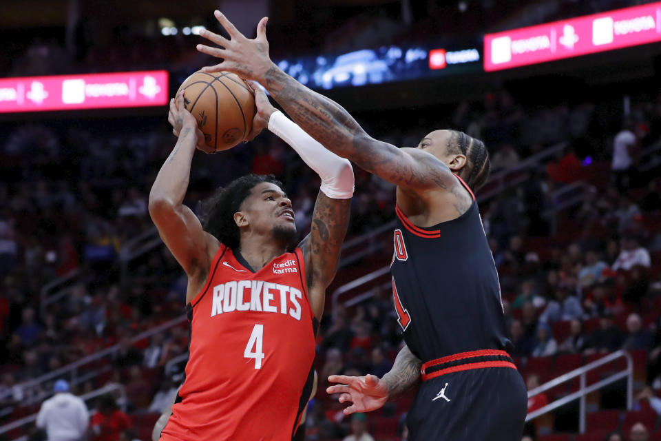 Houston Rockets guard Jalen Green (4) pushes up a shot past Chicago Bulls forward DeMar DeRozan, right, during the first half of an NBA basketball game Thursday, March 21, 2024, in Houston. (AP Photo/Michael Wyke)