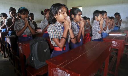 School children pray inside their classroom for the victims of Kolkata's collapsed under-construction flyover, in Agartala, India, April 1, 2016. REUTERS/Jayanta Dey