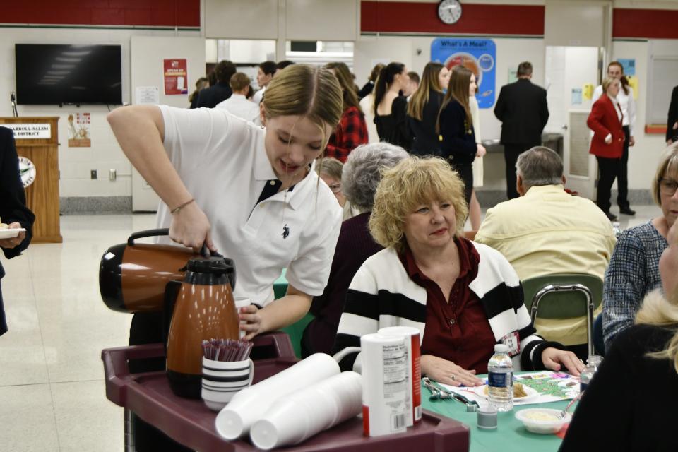 Oak Harbor High School students serve drinks and food to senior citizens during the Benton-Carroll-Salem School District's annual holiday luncheon and concert held Wednesday.