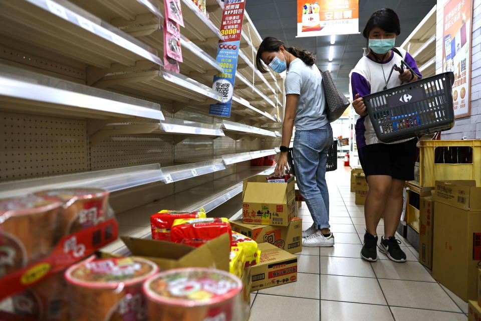 Two women wear protective face masks while shopping for instant noodles following a surge of coronavirus disease (COVID-19) infections in Taipei, Taiwan May 17, 2021. REUTERS/Ann Wang