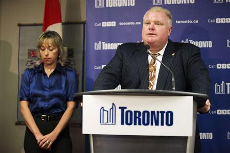 Toronto Mayor Rob Ford speaks at a news conference with his wife Renata (L) at City Hall in Toronto, November 14, 2013. REUTERS/Mark Blinch