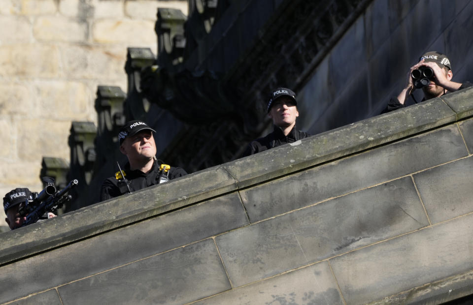 Security are placed on the balcony prior to the departure of the hearse carrying Queen Elizabeth's coffin from St Giles Cathedral en route to Edinburgh Airport in Edinburgh, Scotland, Tuesday, Sept. 13, 2022. After lying in the cathedral most of Tuesday, the queen's coffin will be flown back to London and driven to her official London home, Buckingham Palace. (AP Photo/Bernat Armangue)