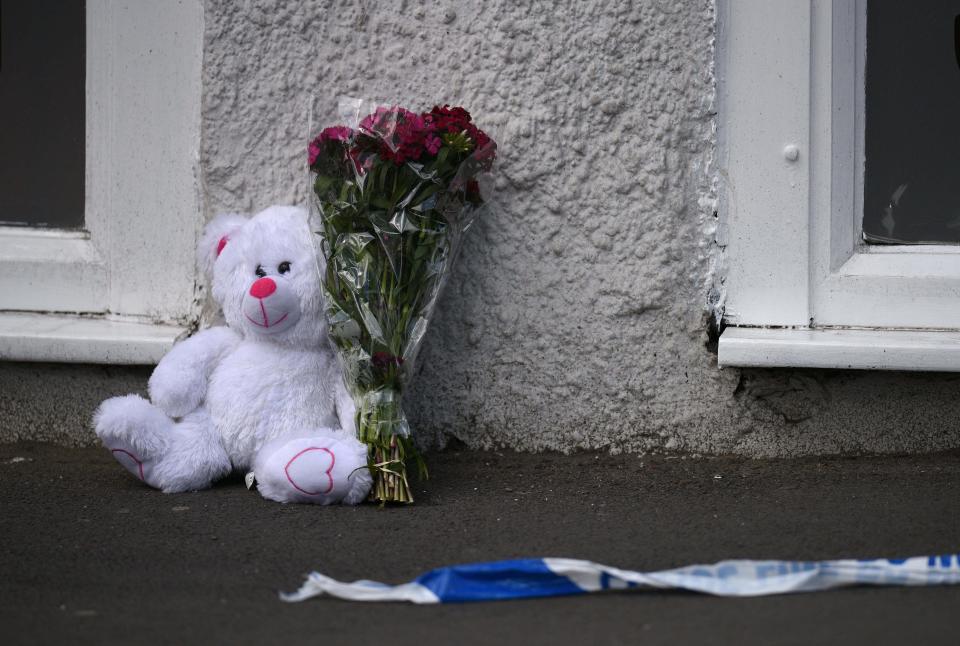 A floral tribute and a teddy bear are pictured alongside police tape near to the Manchester Arena.&nbsp;