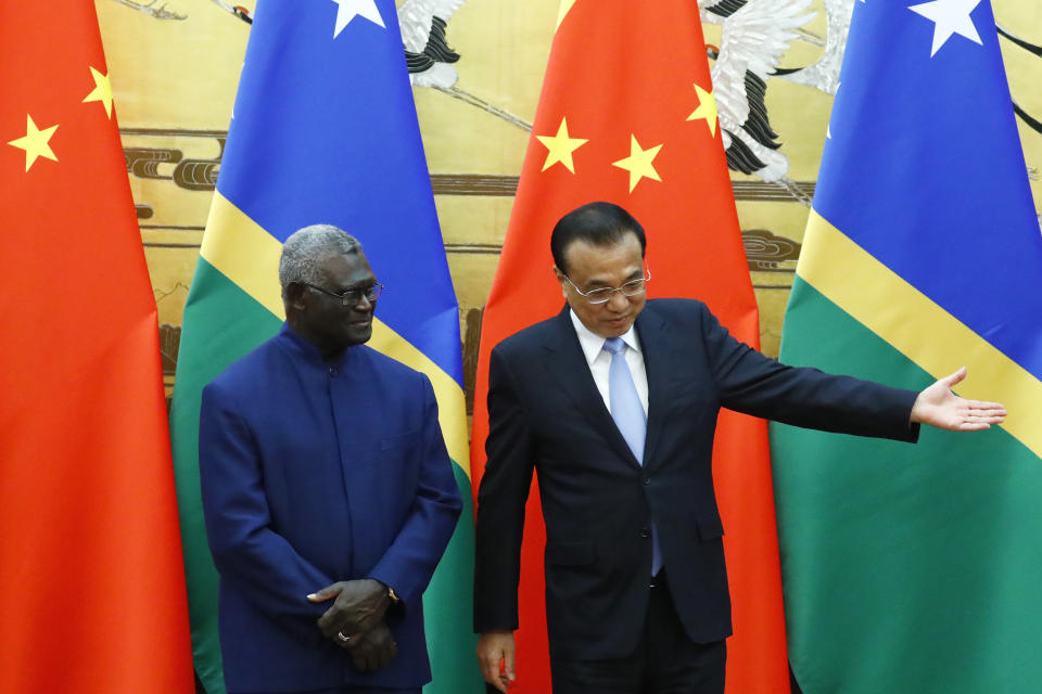 FILE - Solomon Islands Prime Minister Manasseh Sogavare, left, and Chinese Premier Li Keqiang attend a signing ceremony at the Great Hall of the People in Beijing, Wednesday, Oct. 9, 2019. The Solomon Islands' decision to switch its diplomatic allegiance from Taiwan to Beijing in 2019, has been blamed for arson and looting in the capital Honiara, where protesters are demanding the prime minister's resignation. (Thomas Peter/Pool Photo via AP, File)