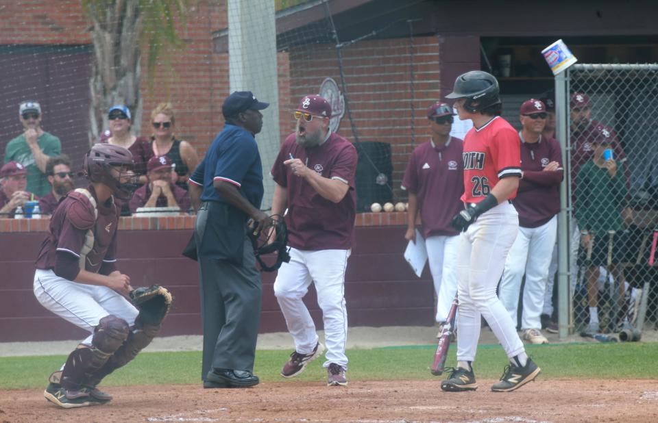 Benedictine pitching coach Mike Proto argues with the home-plate umpire after being ejected from the first game of Saturday's state semifinal playoff match-up against North Oconee.